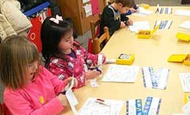 Children sitting at a table coloring