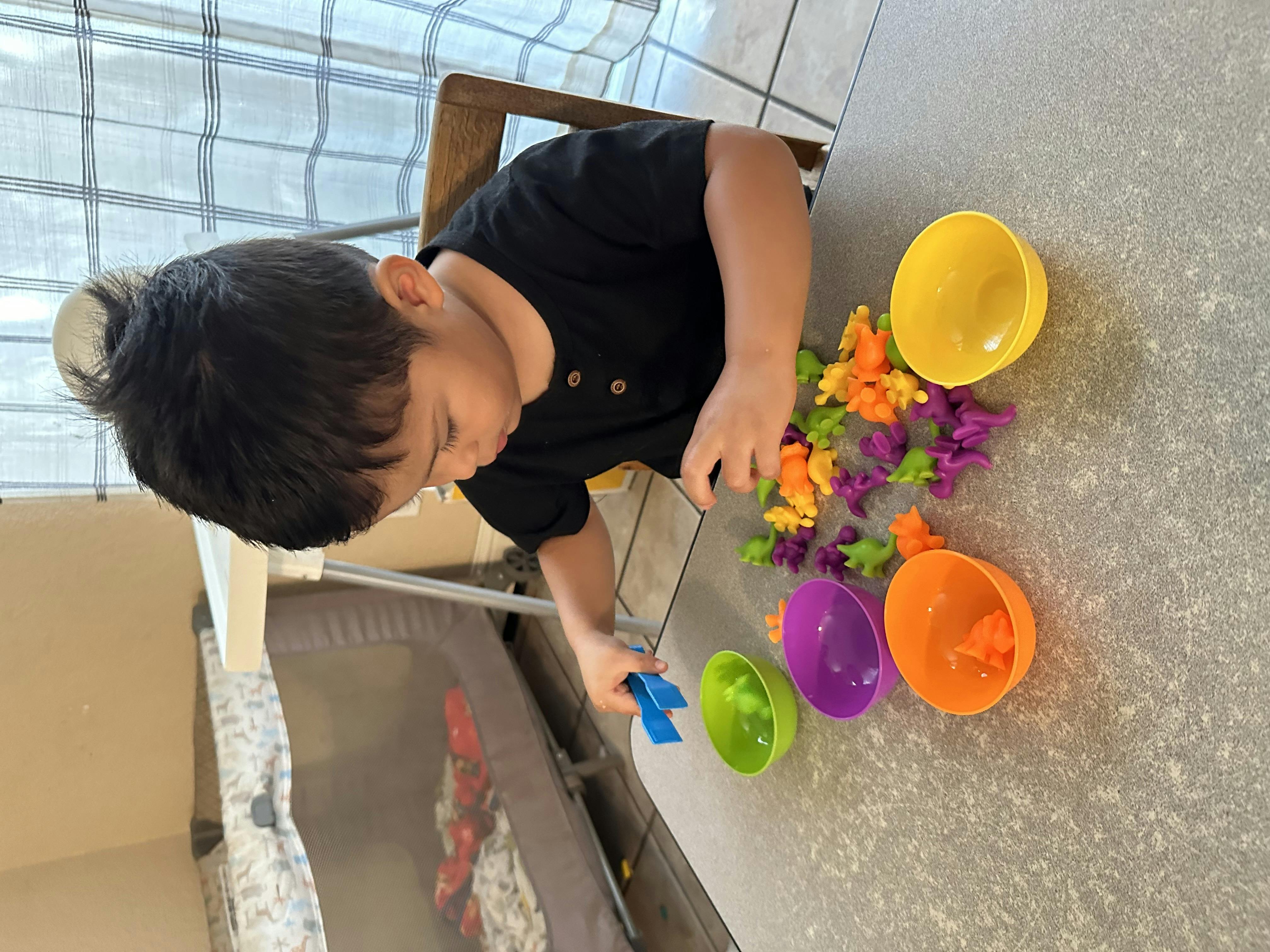 Child playing with colorful toys and bowls