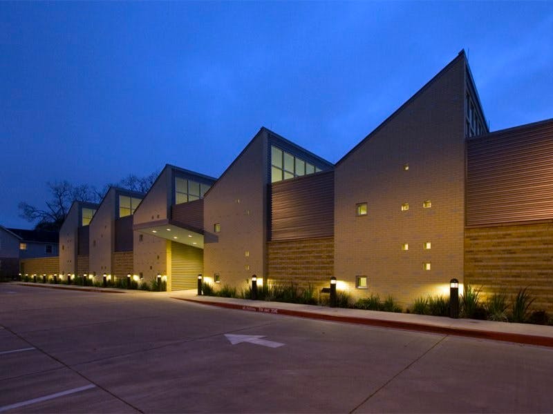 Modern building with angular rooflines and illuminated facade at night