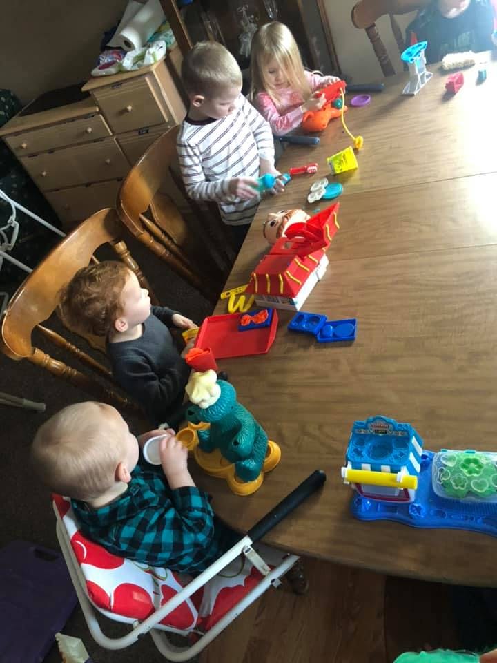 Four children playing with toys at a table