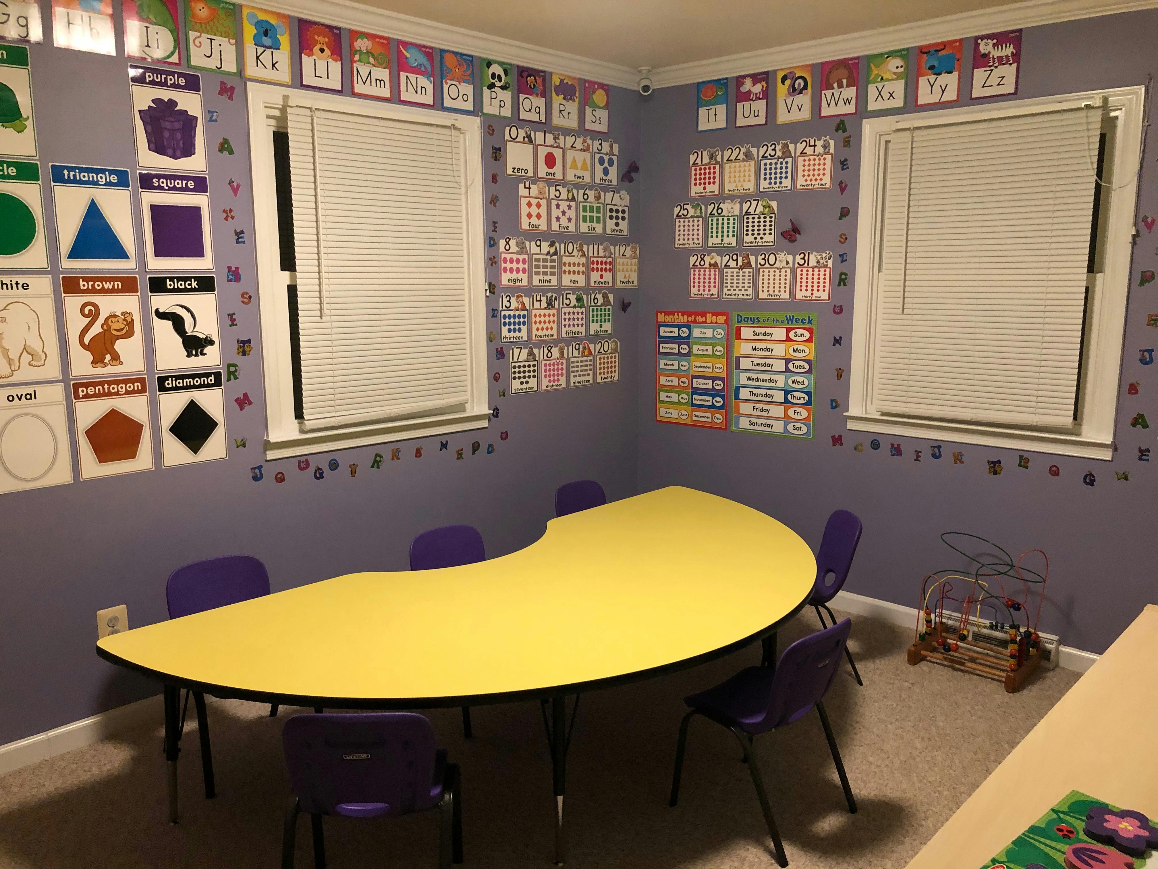 Classroom with a yellow crescent-shaped table and purple chairs