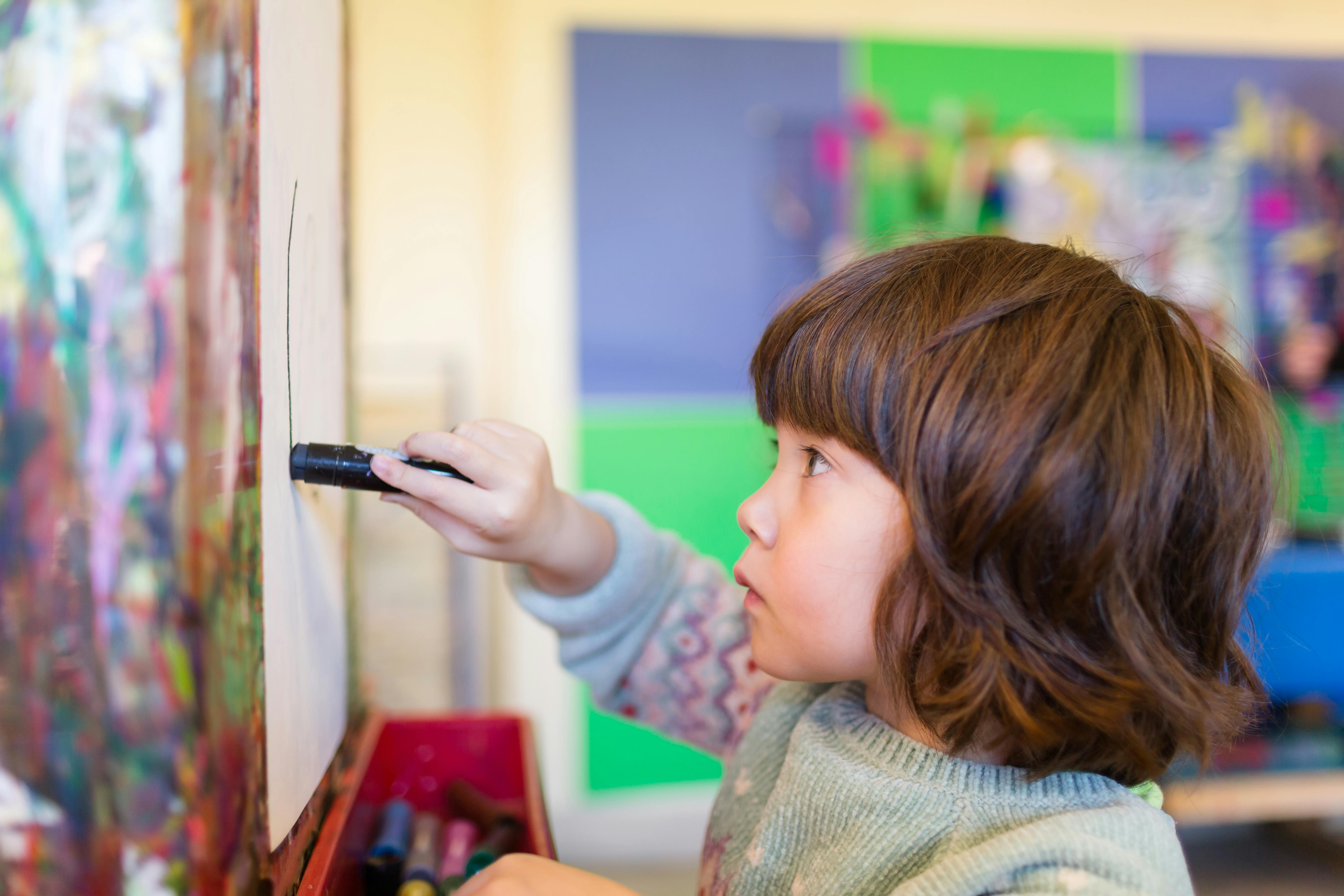 Child drawing on an easel