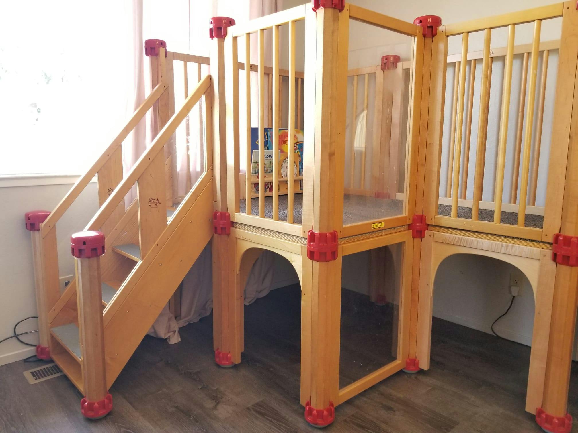 Wooden indoor play structure with stairs and platforms