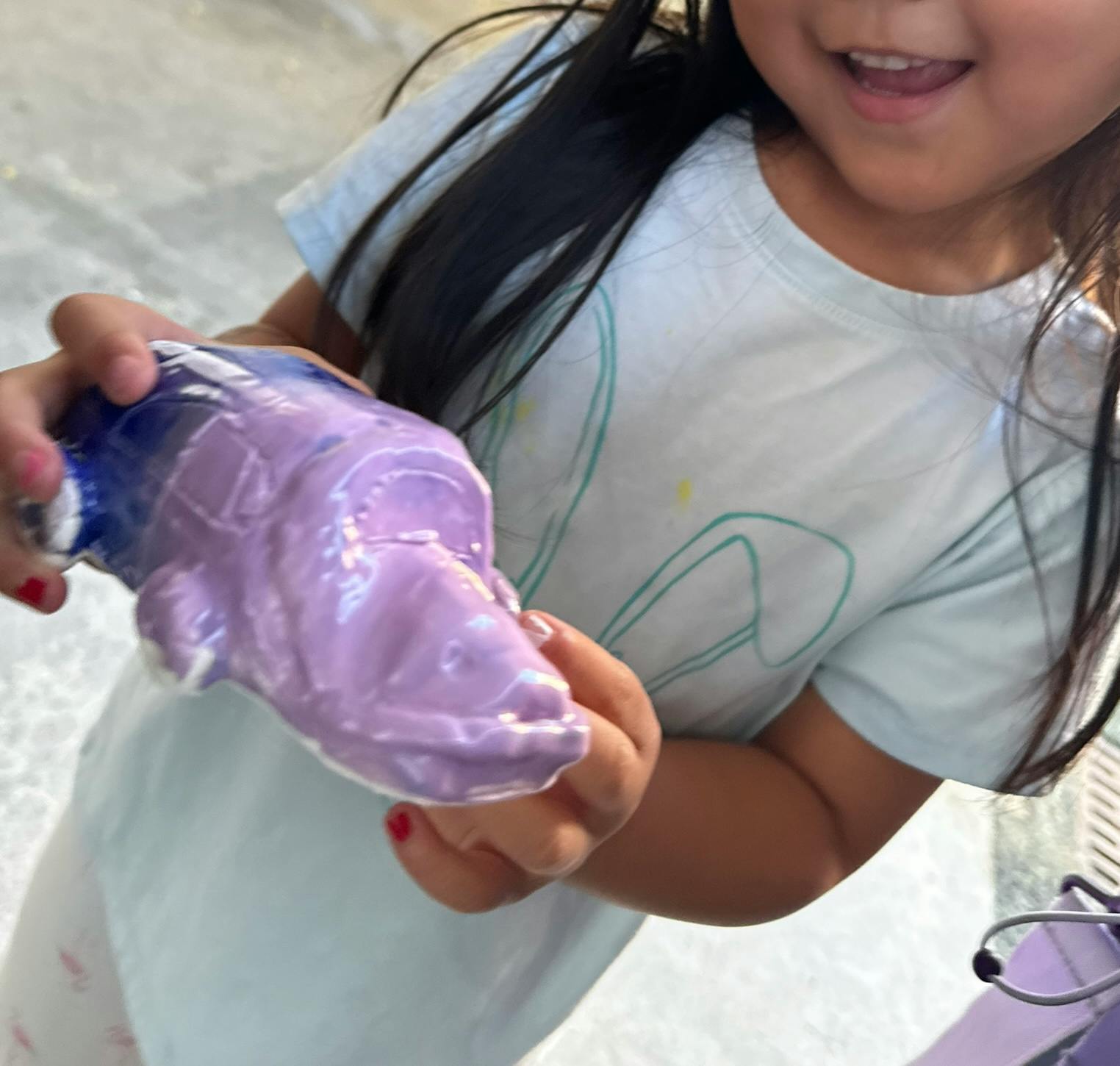Child holding a bottle with purple slime coming out