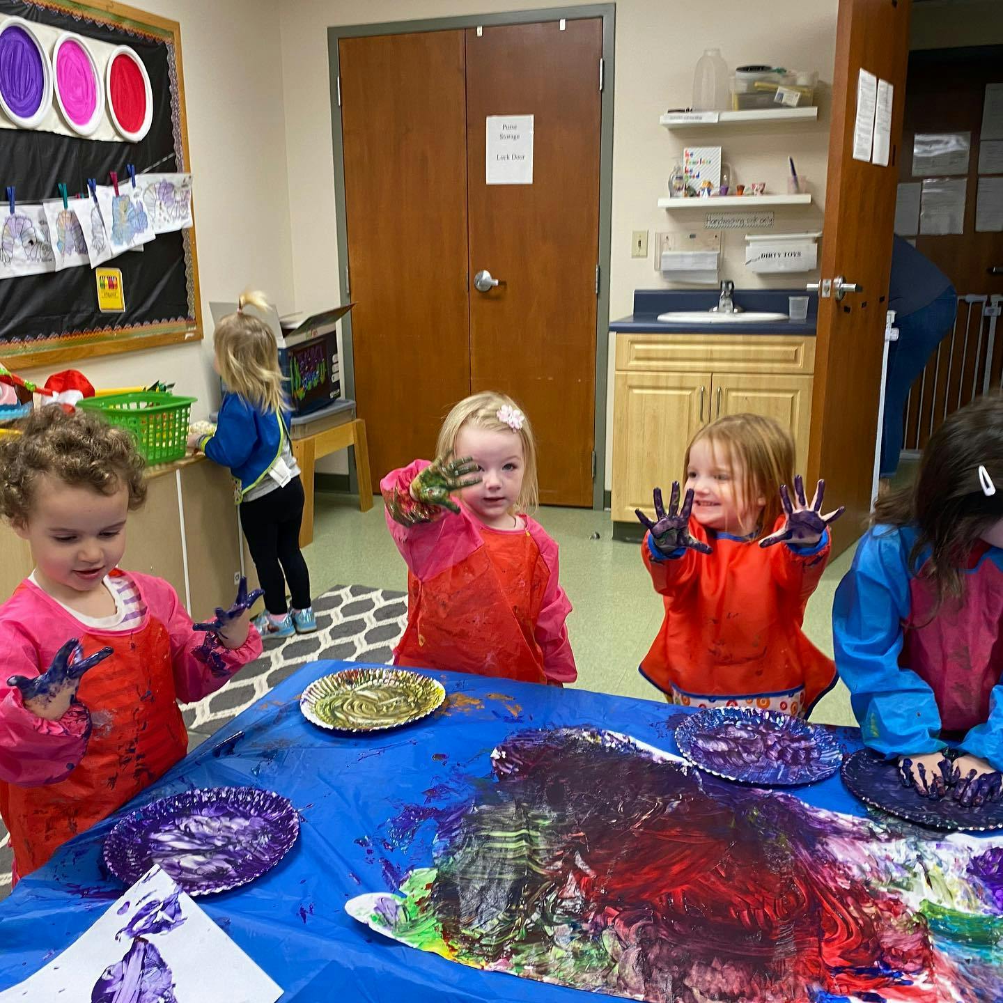 Children finger painting in a classroom