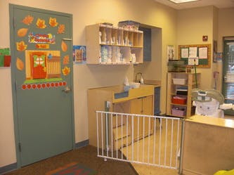 Childcare room with a decorated door and changing station