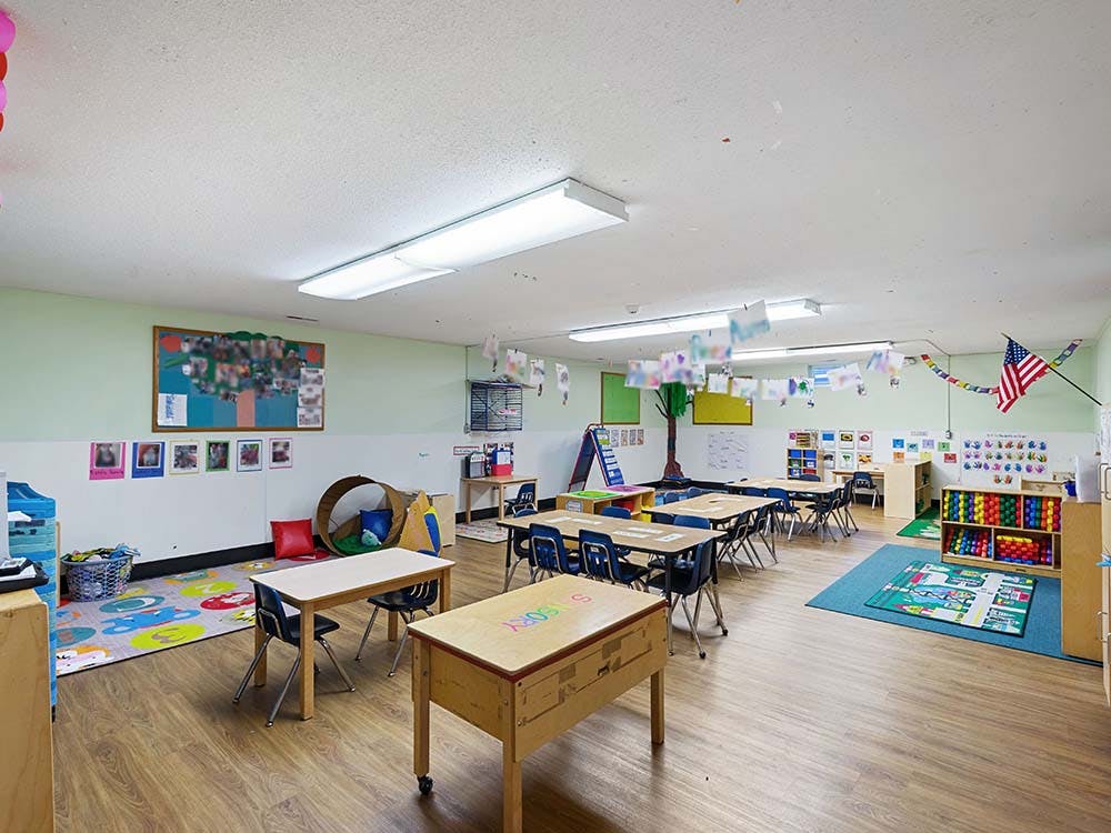 Empty colorful children's classroom with small tables and chairs