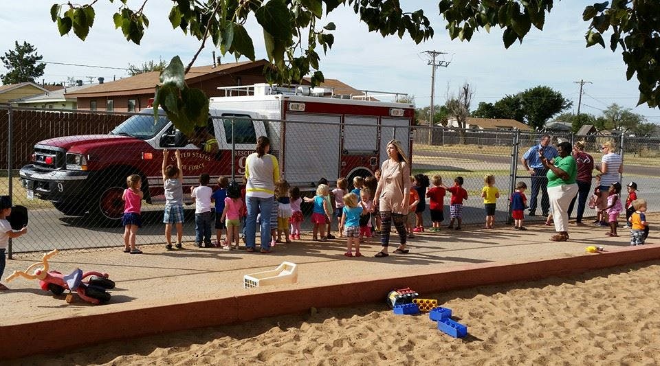 People and children gathered around a fire truck