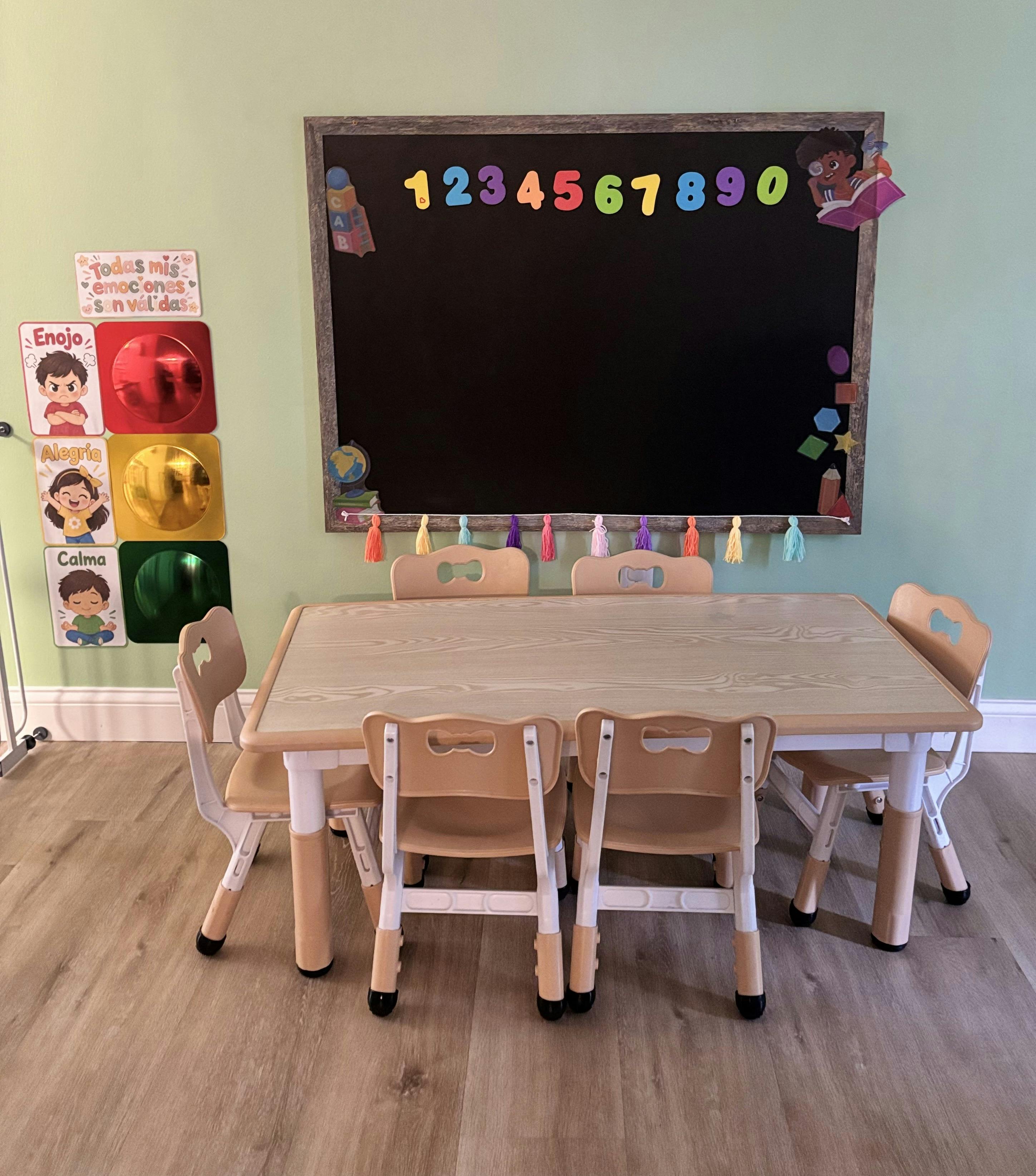 Child-sized table and chairs in a classroom with a chalkboard and wall decor