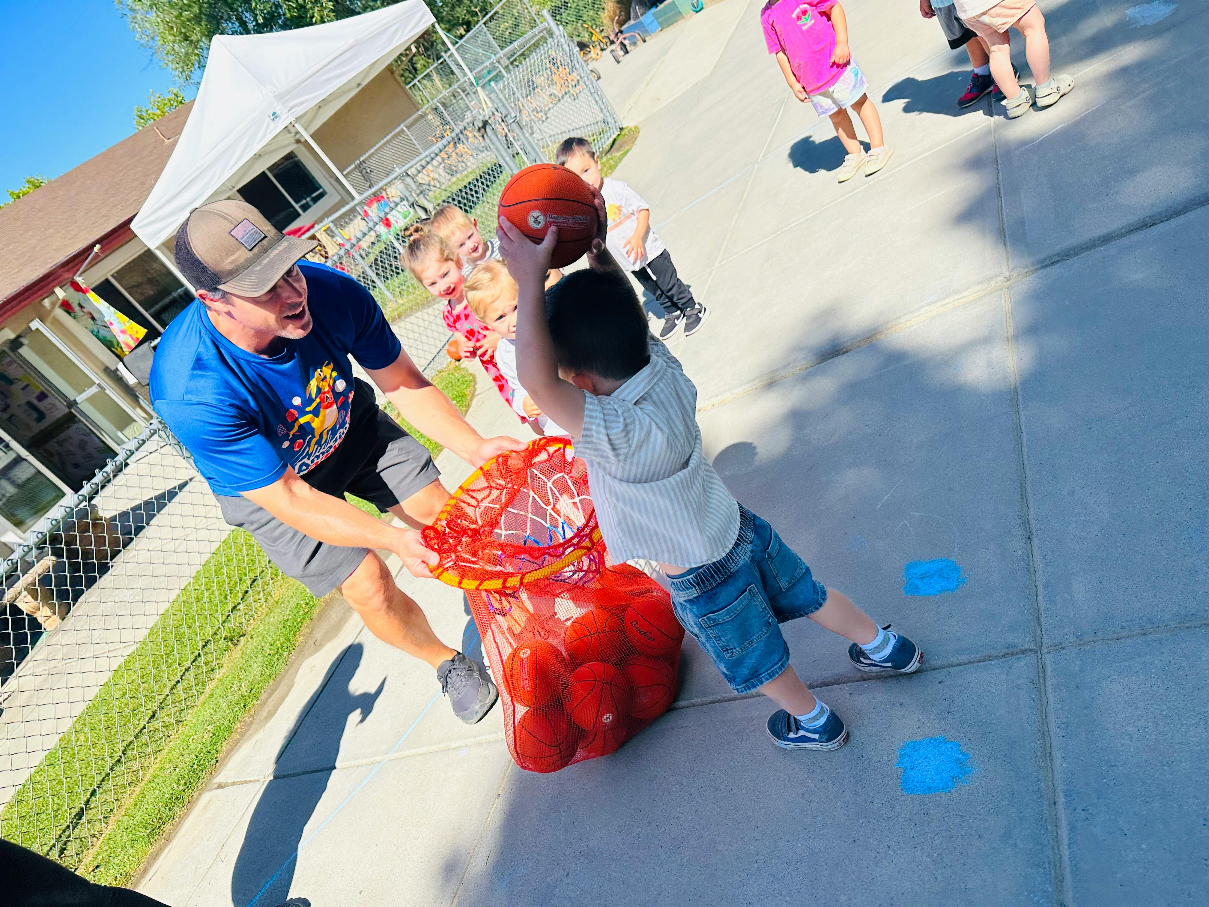 Adult and child playing with basketballs outdoors