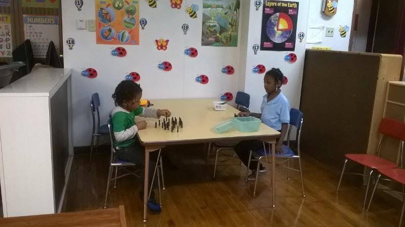 Two children sitting at a table in a classroom