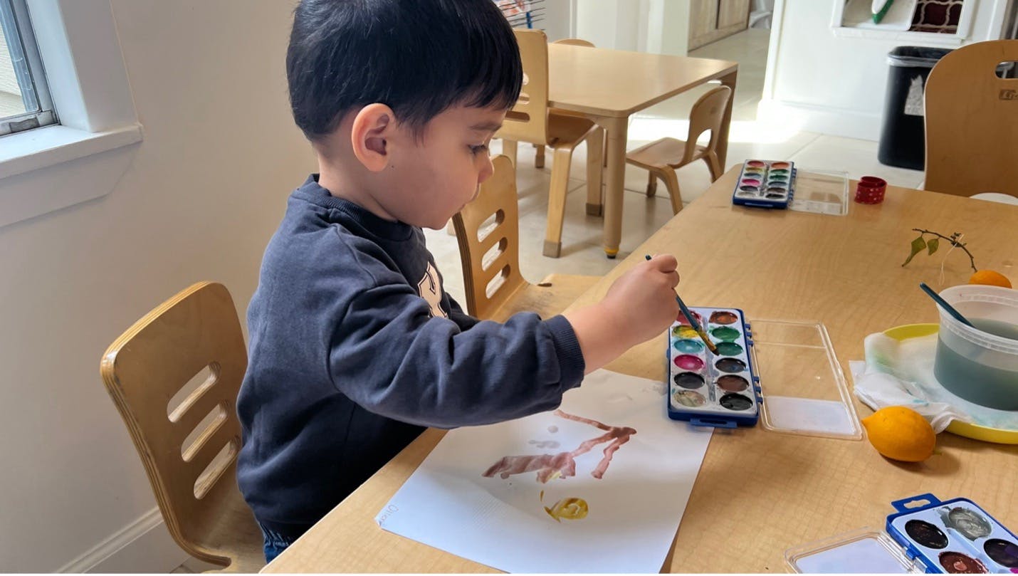 Child painting with watercolors at a table