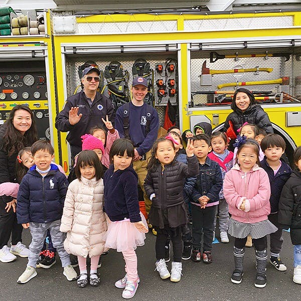 Adults and children posing in front of a fire truck