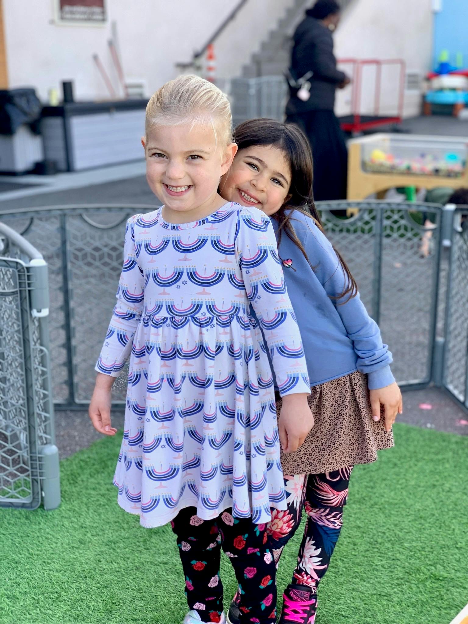 Two children standing together, one child leaning on the other