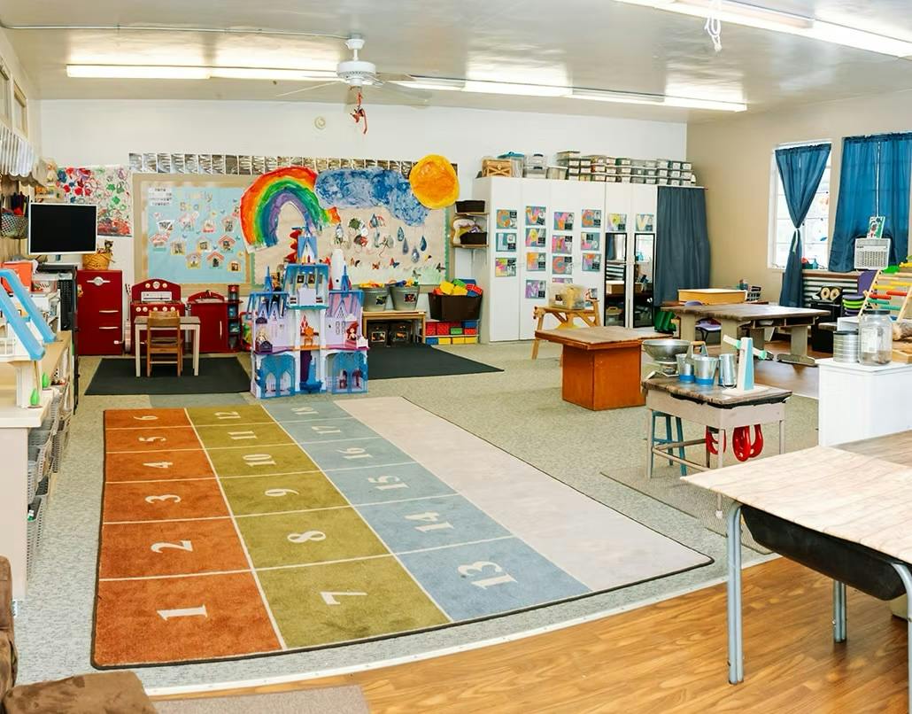 Colorful classroom with tables and a number rug