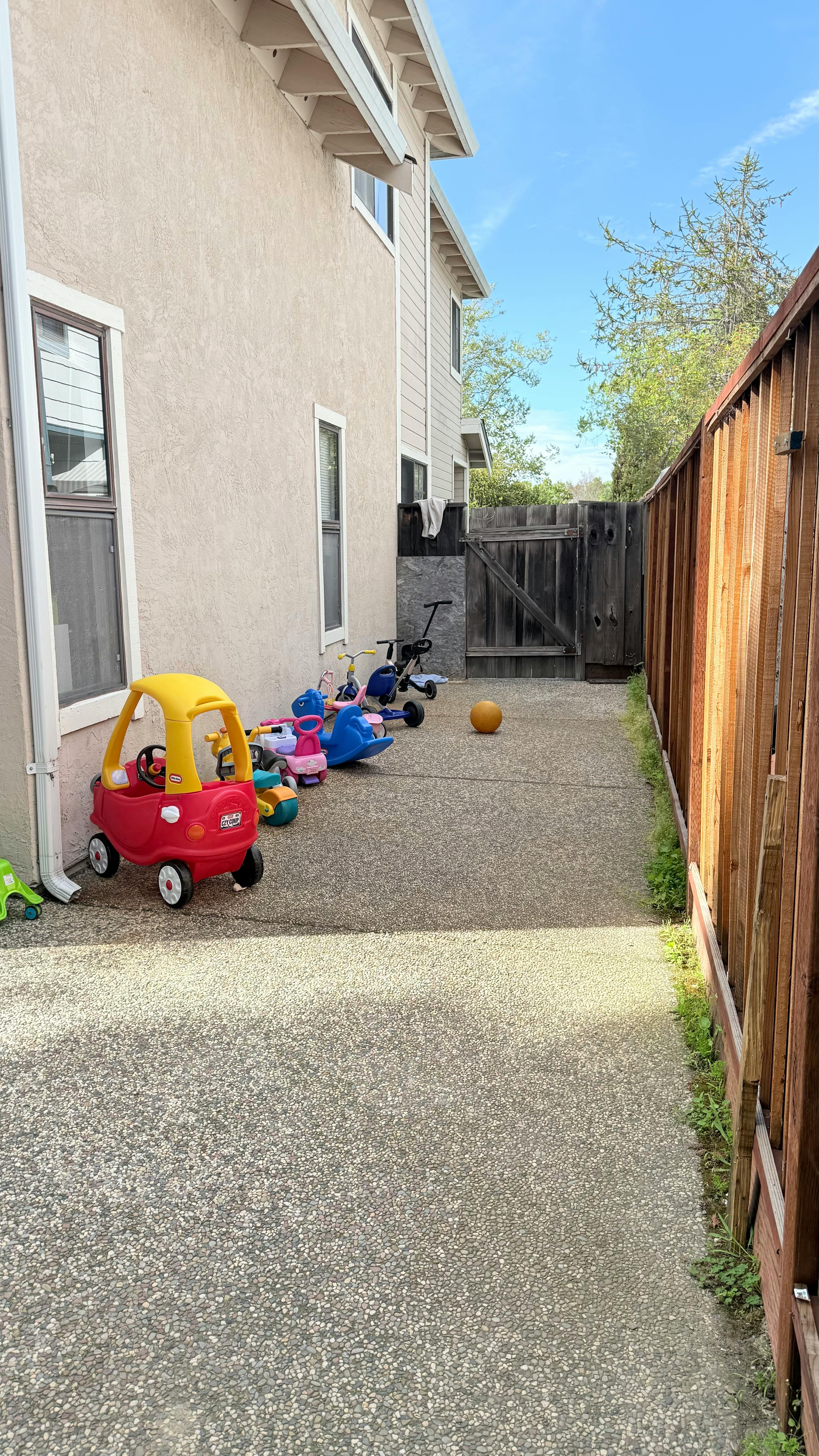 Children's ride-on toys lined up against a building