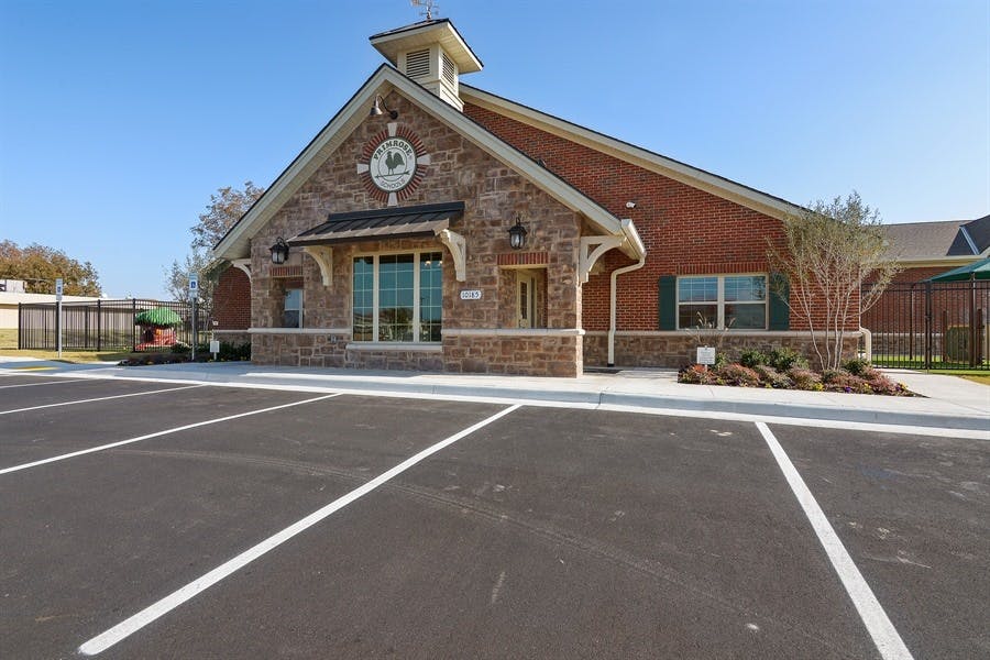 Building with brick and stone facade and a parking lot in front
