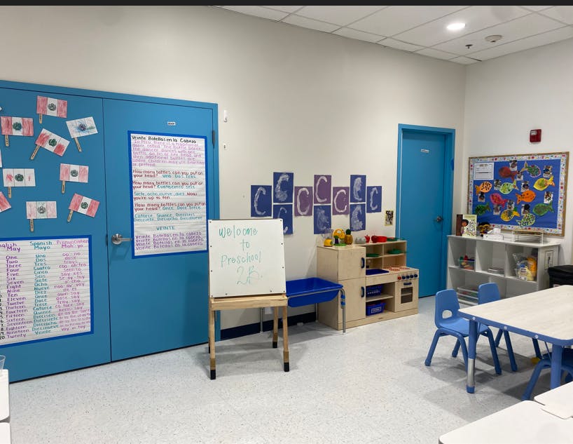 Classroom with blue doors, whiteboard, and children's furniture