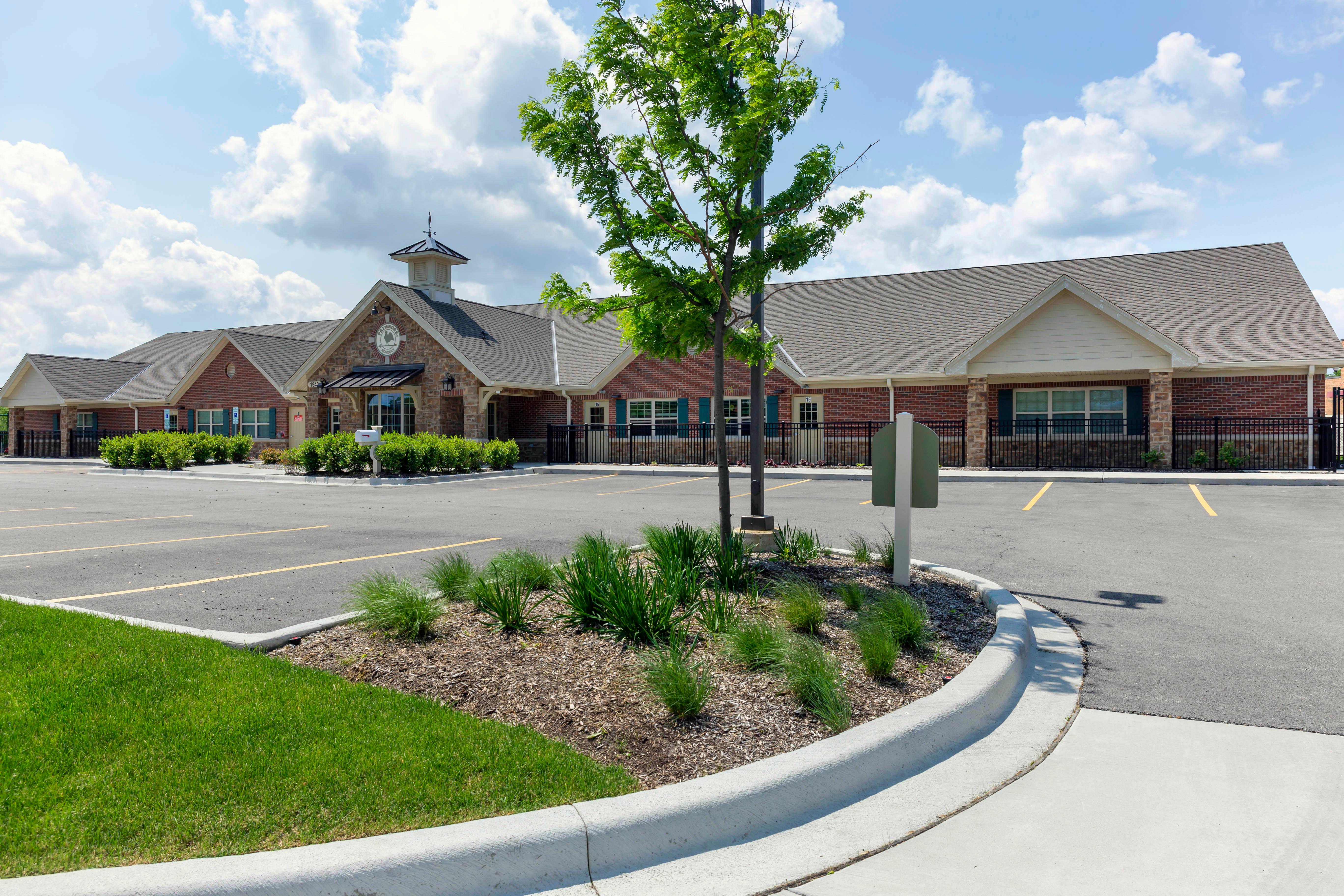 Brick building with a stone entrance and a parking lot in front