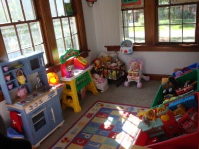 Children's play area with toy kitchen, activity table, and storage bins