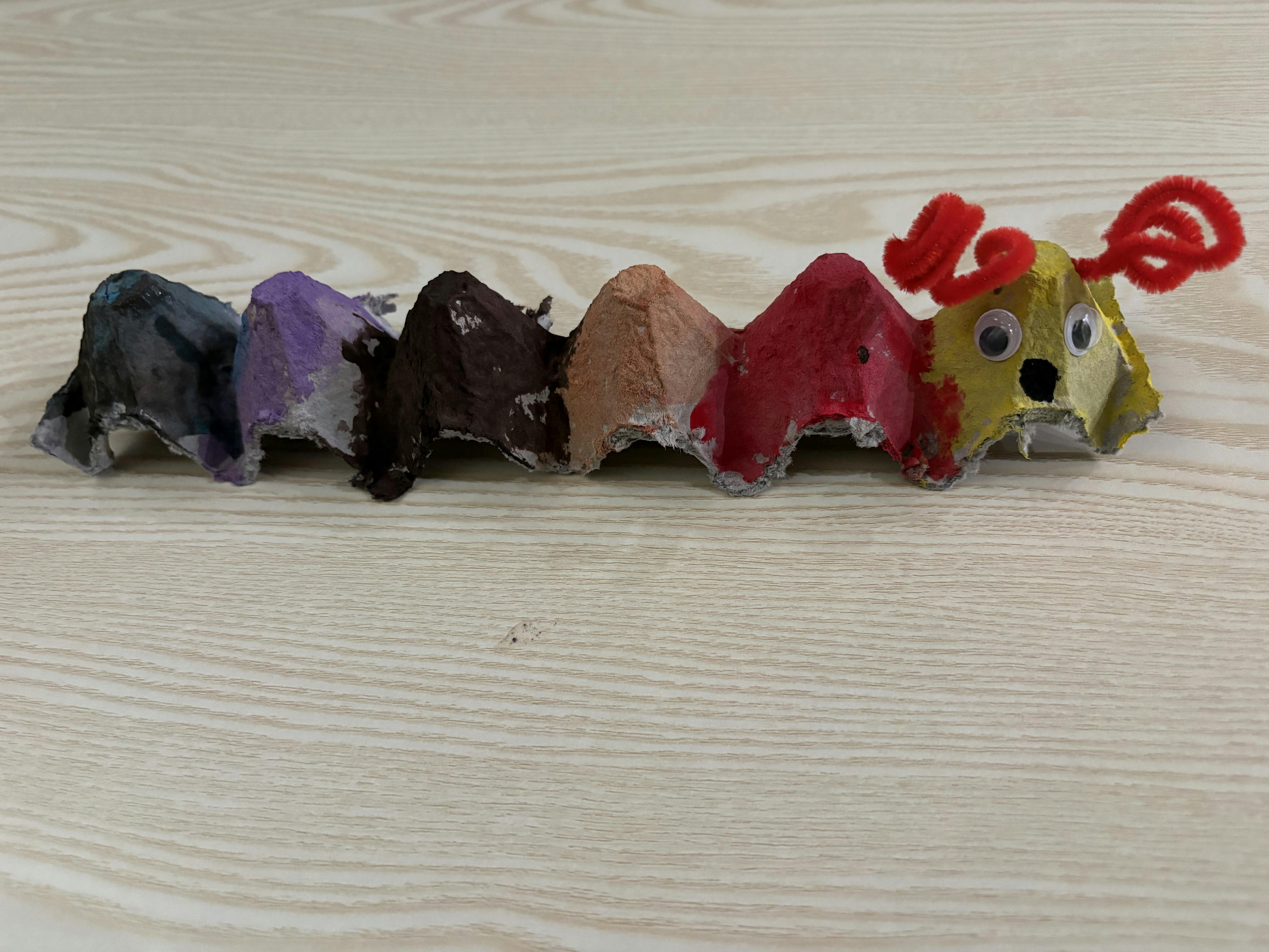 Caterpillar craft made from painted egg carton segments with googly eyes