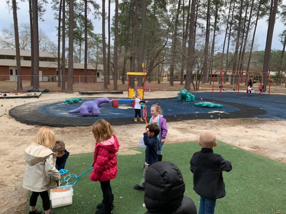 Children playing on a playground with sand and rubber surfaces
