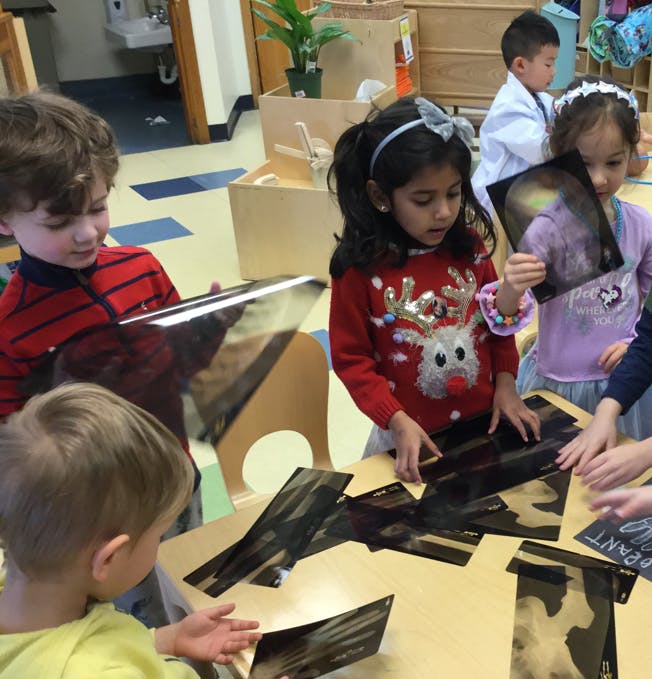 Children looking at images on a table in a classroom