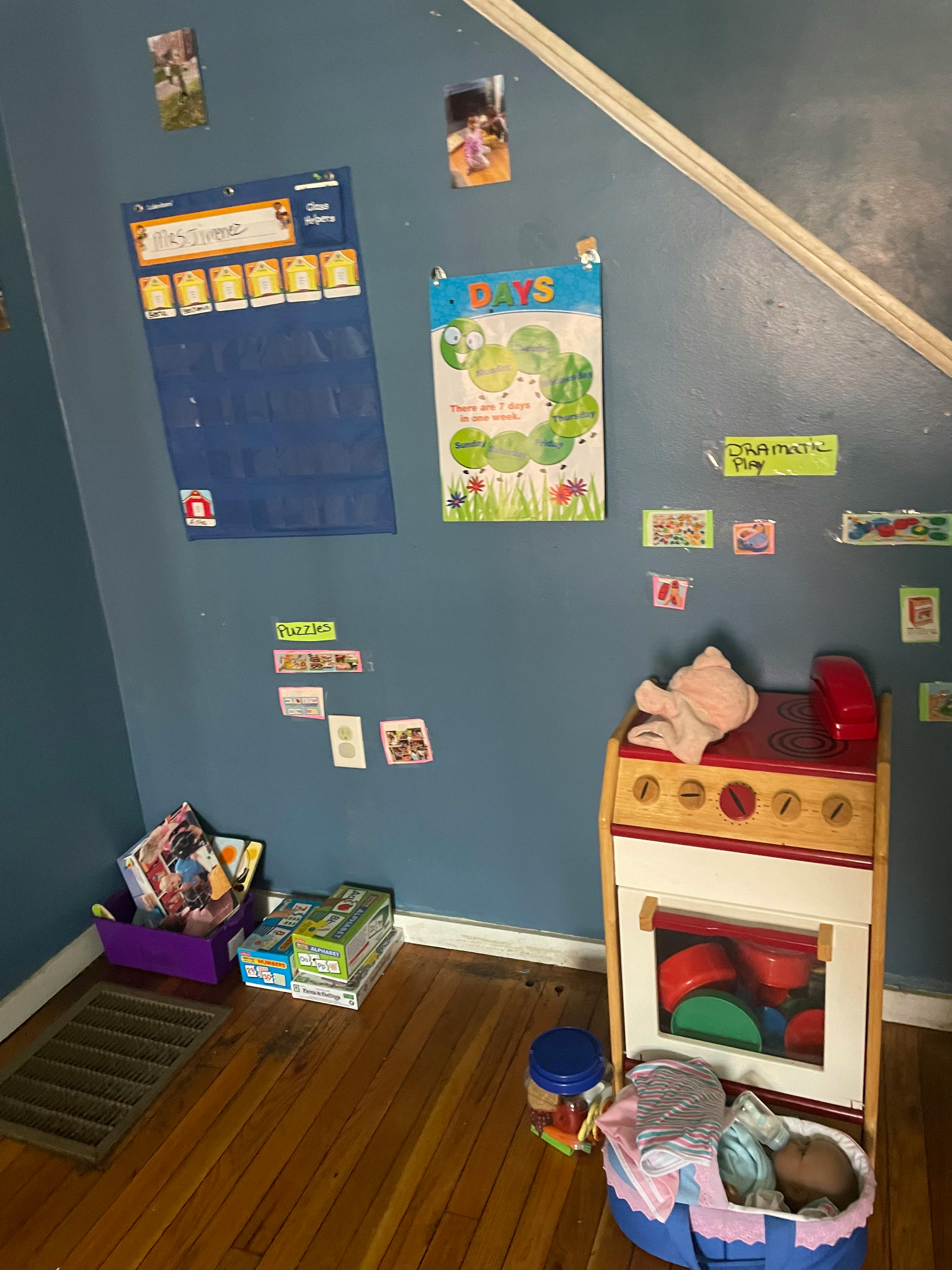 Child's play kitchen with a baby doll in a basket next to it