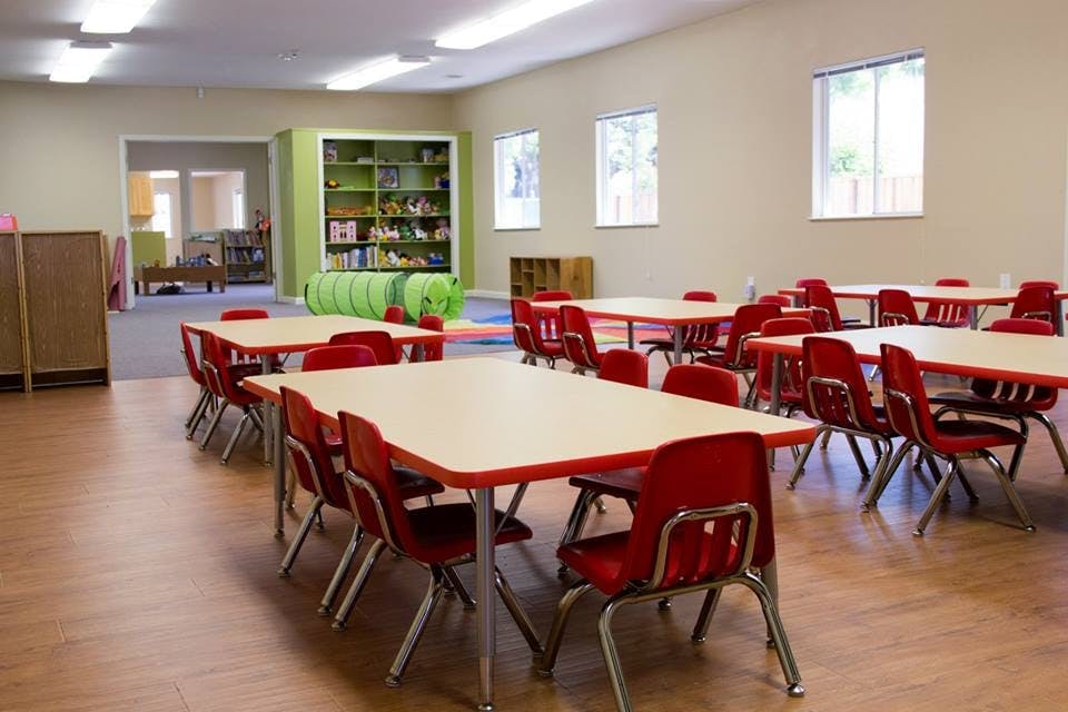 Classroom with small tables and red chairs
