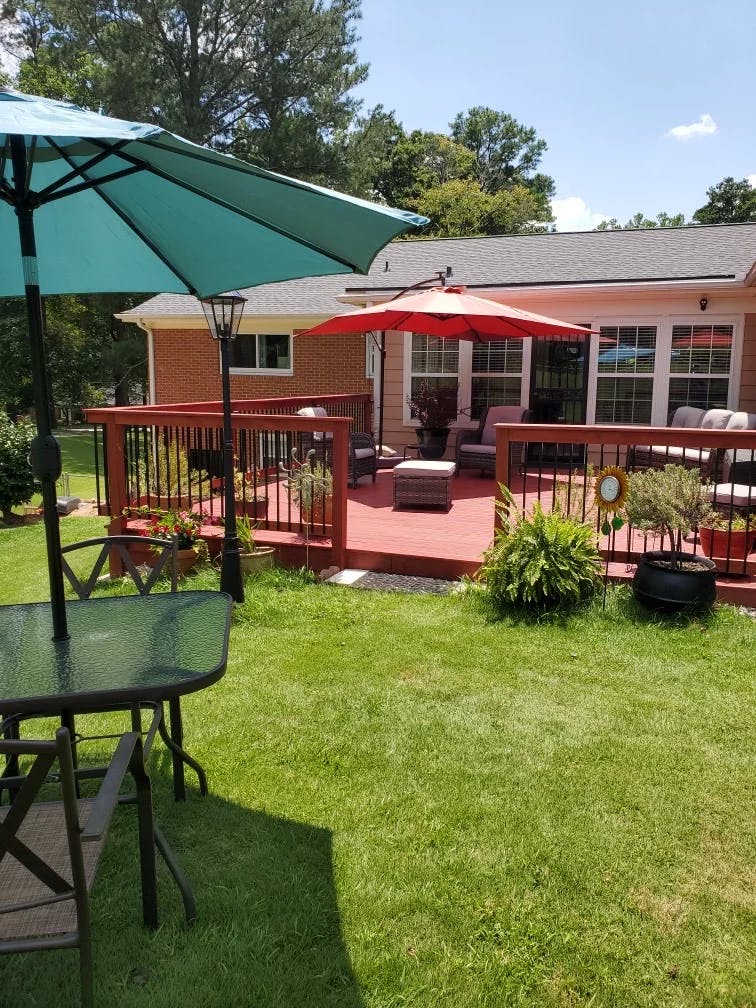 Backyard with a red deck and two open patio umbrellas