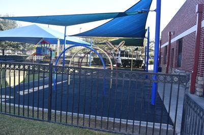 Playground with blue shade sails and climbing structures