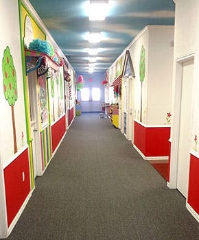 Long hallway with colorful decorations and red wainscoting