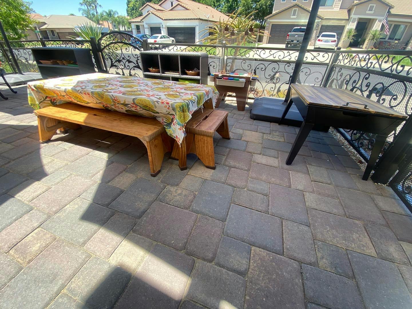 Outdoor patio with a table covered by a tablecloth and two wooden benches