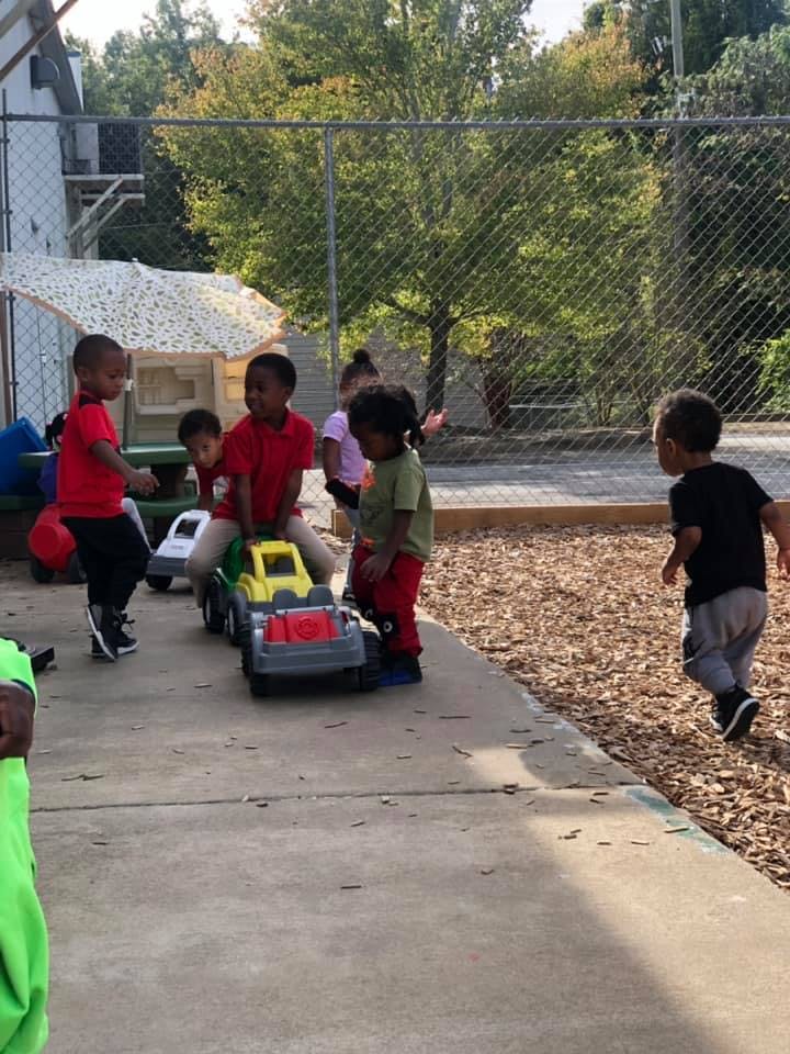 Children playing with toy trucks outdoors