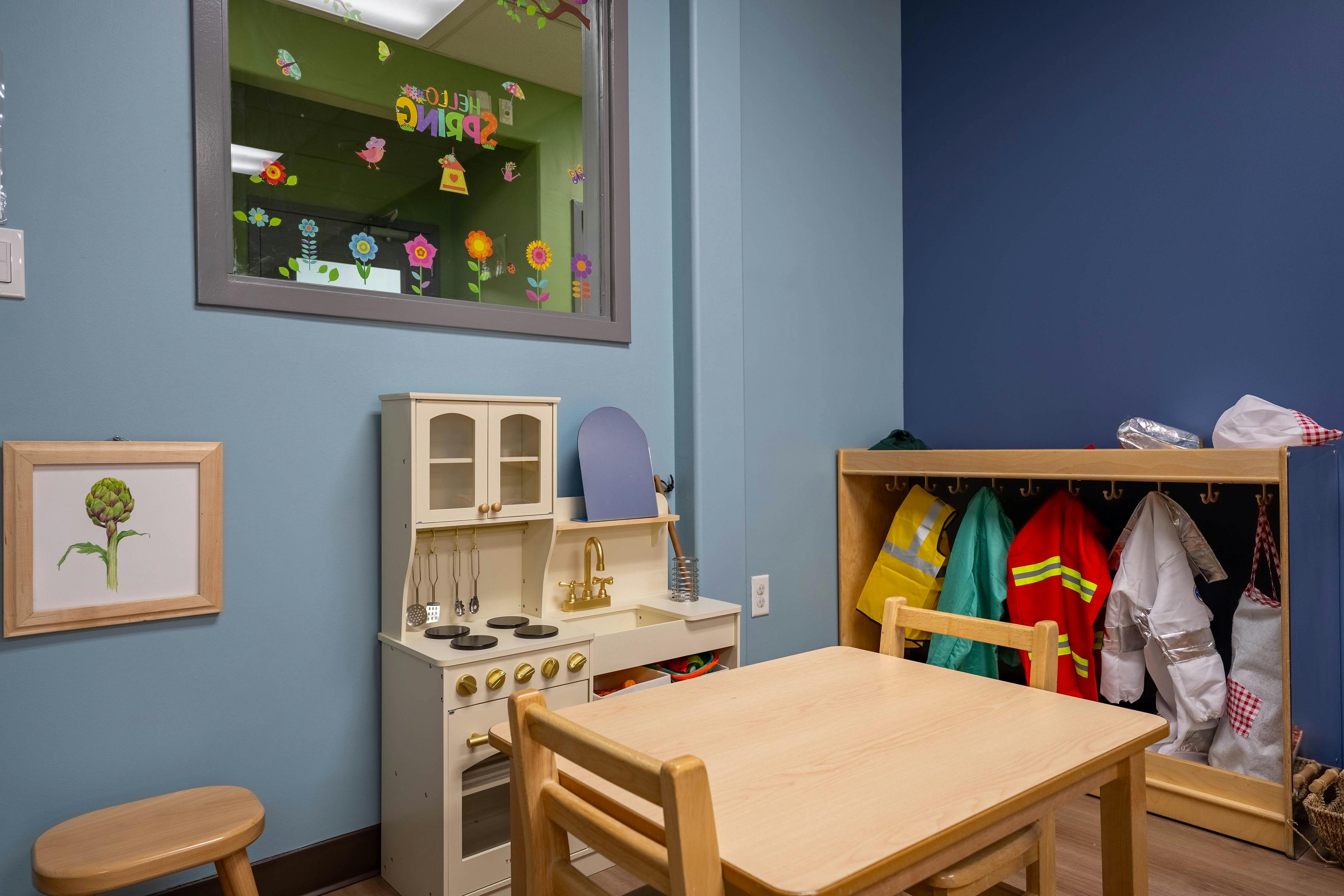 Child's play kitchen set and table with dress-up clothes