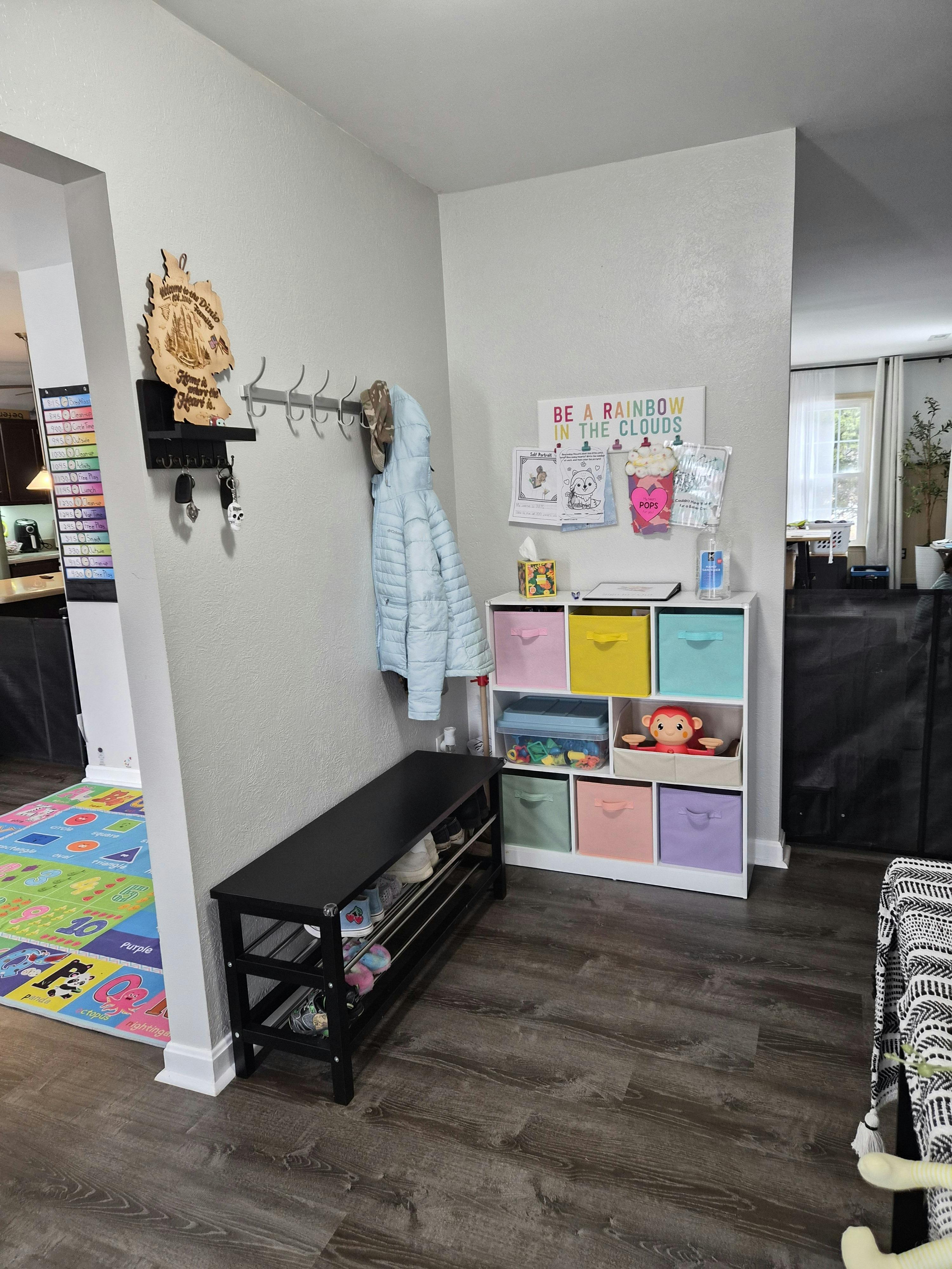 Entryway with a coat rack, shoe bench, and cubby organizer with colorful bins