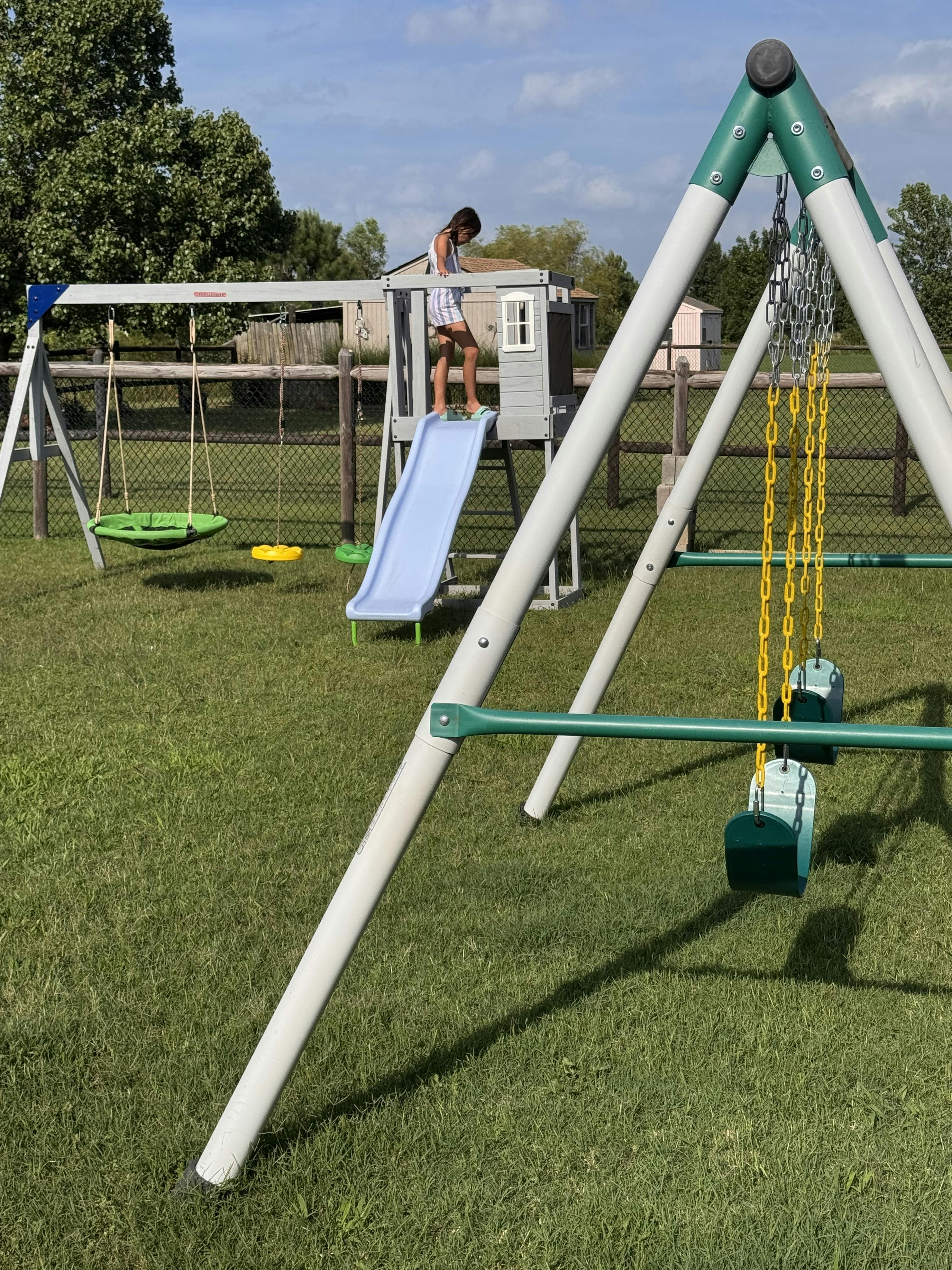 Child standing on a backyard play set platform