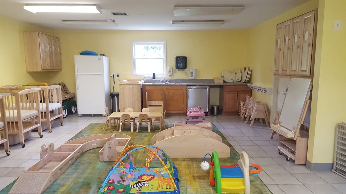 Playroom with cribs, small tables, and play equipment