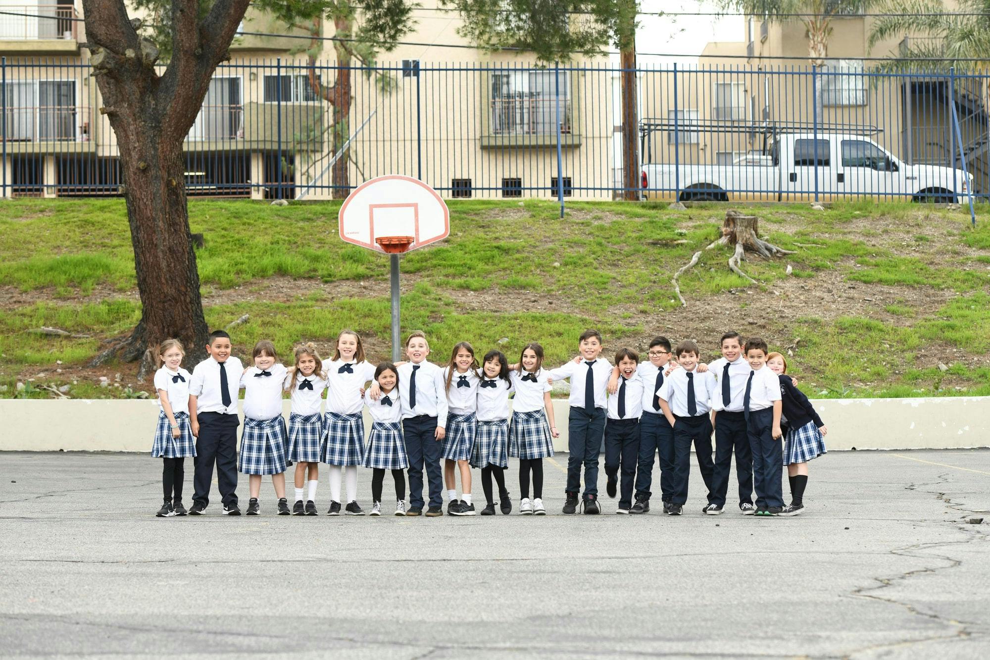 Children in school uniforms posing on a basketball court