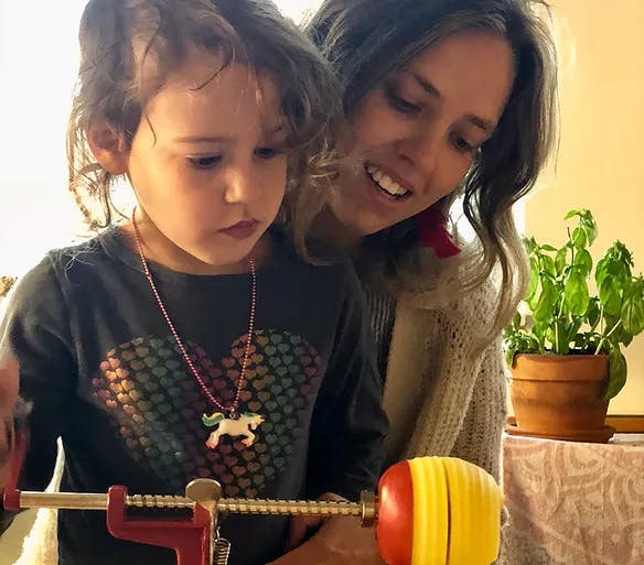 Person and child using an apple peeler