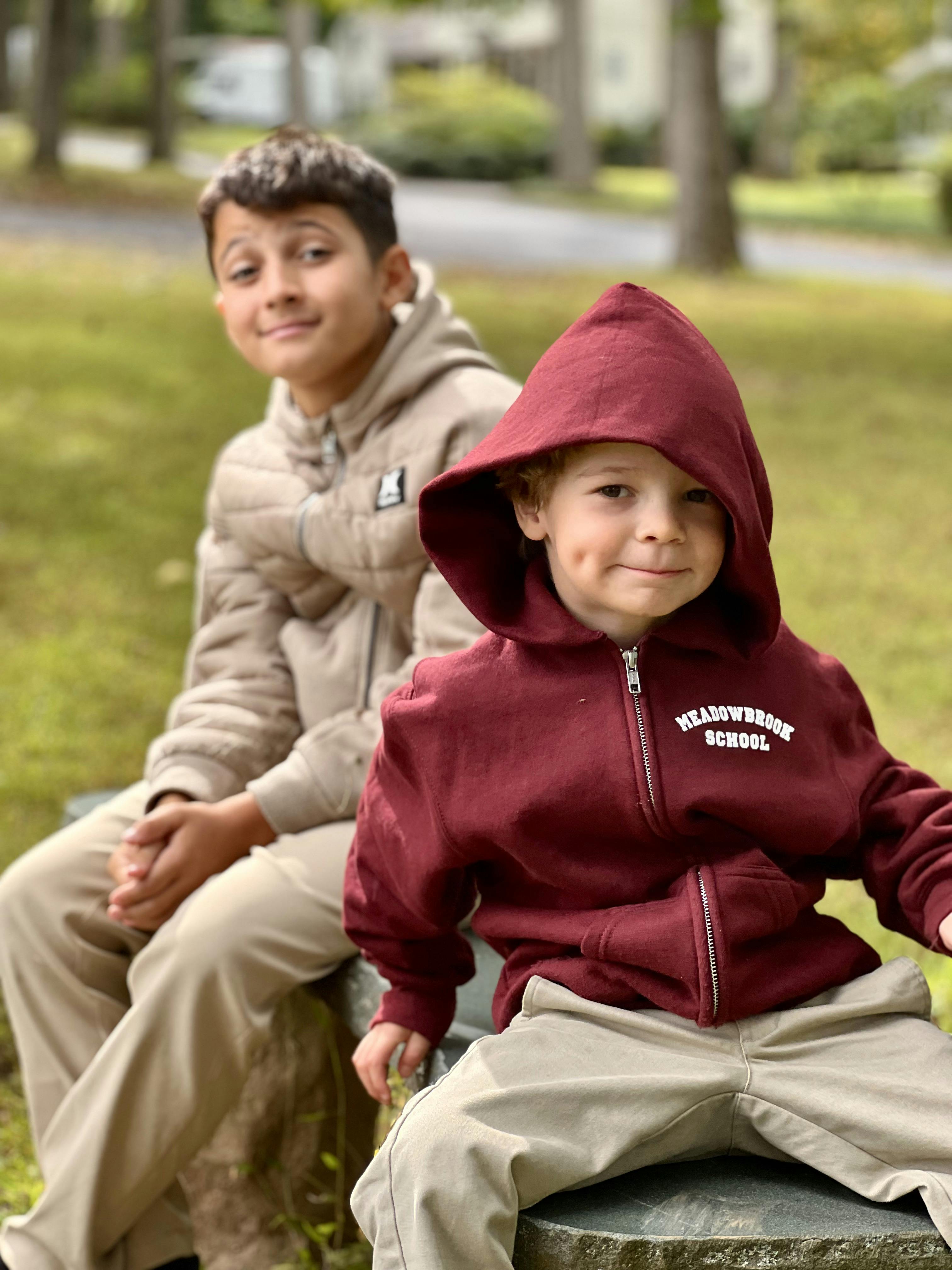 Two children sitting on a bench outdoors