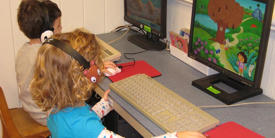 Two children wearing headphones at computers