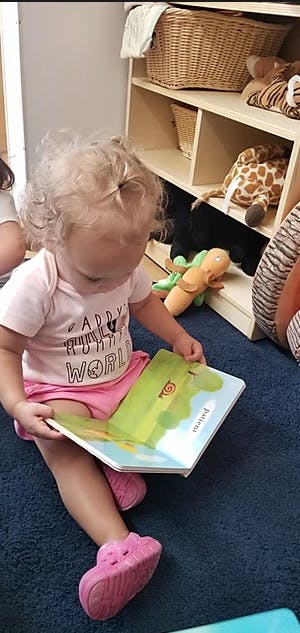 Child sitting on floor reading a book