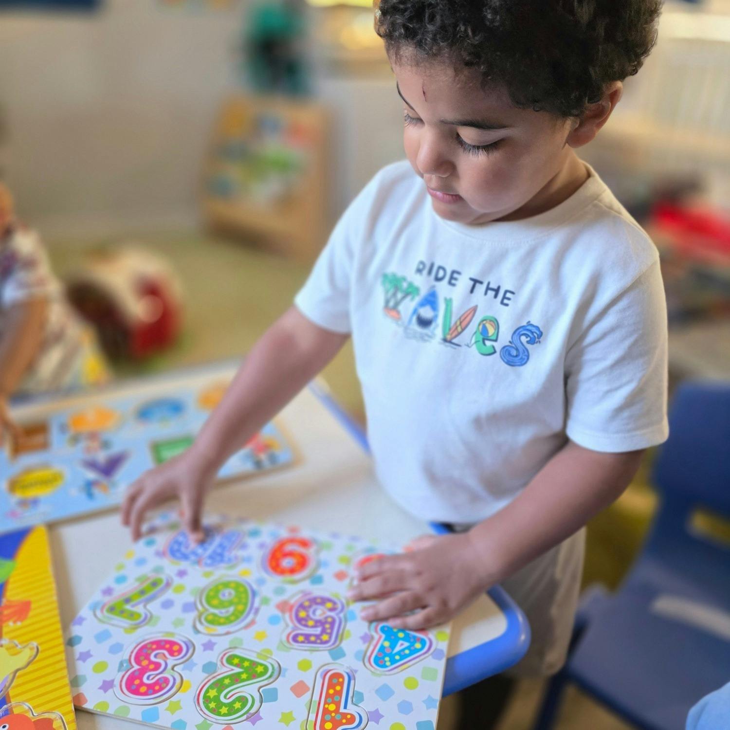 Child playing with a number puzzle in a classroom