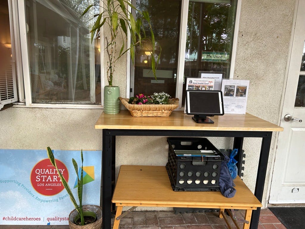 Table with a tablet, plants, and a crate with a sign that says "Quality Start"