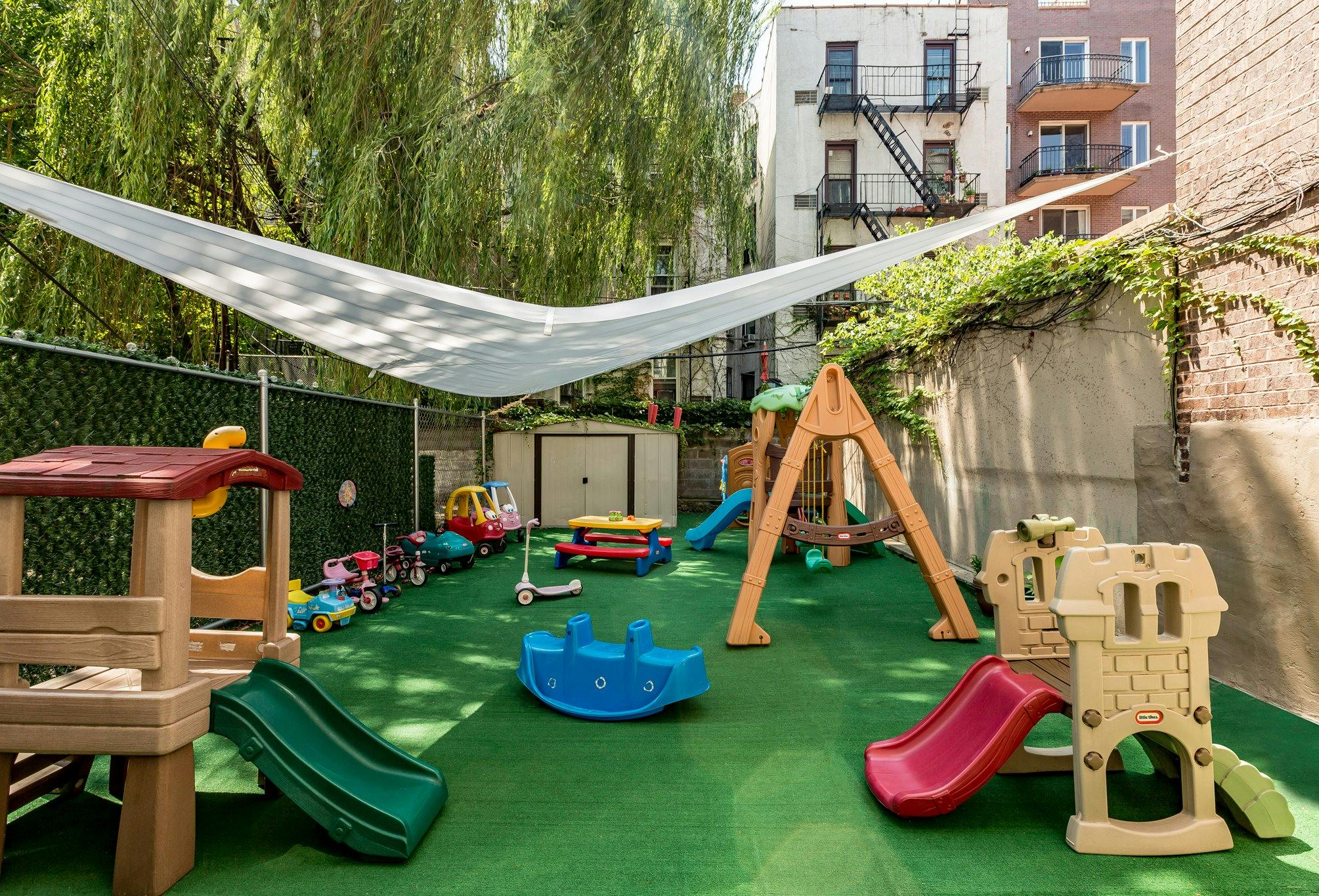 Outdoor playground with slides, swings, and various toys on green turf