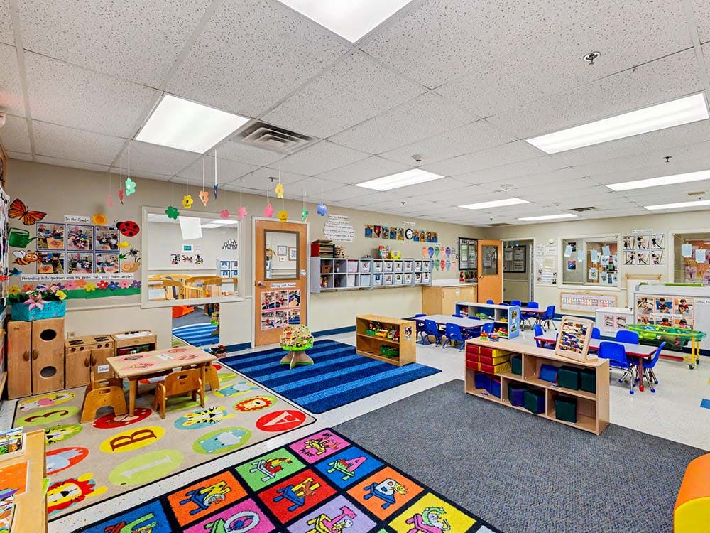 Colorful preschool classroom with play mats and small tables