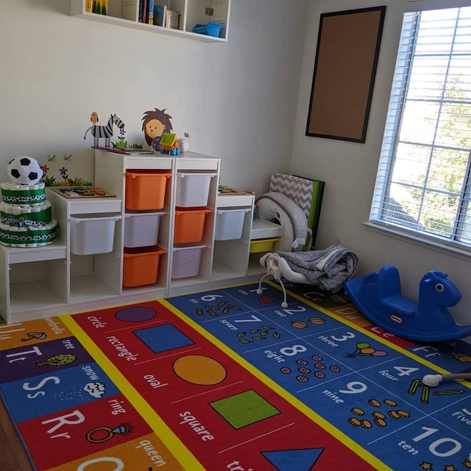 Child's room with toy storage, colorful rug, and window