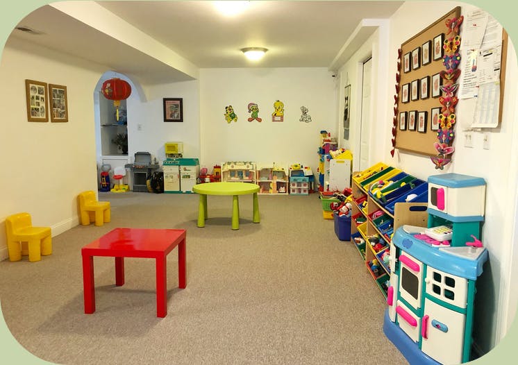 Playroom with small tables and chairs, toys, and wall decorations