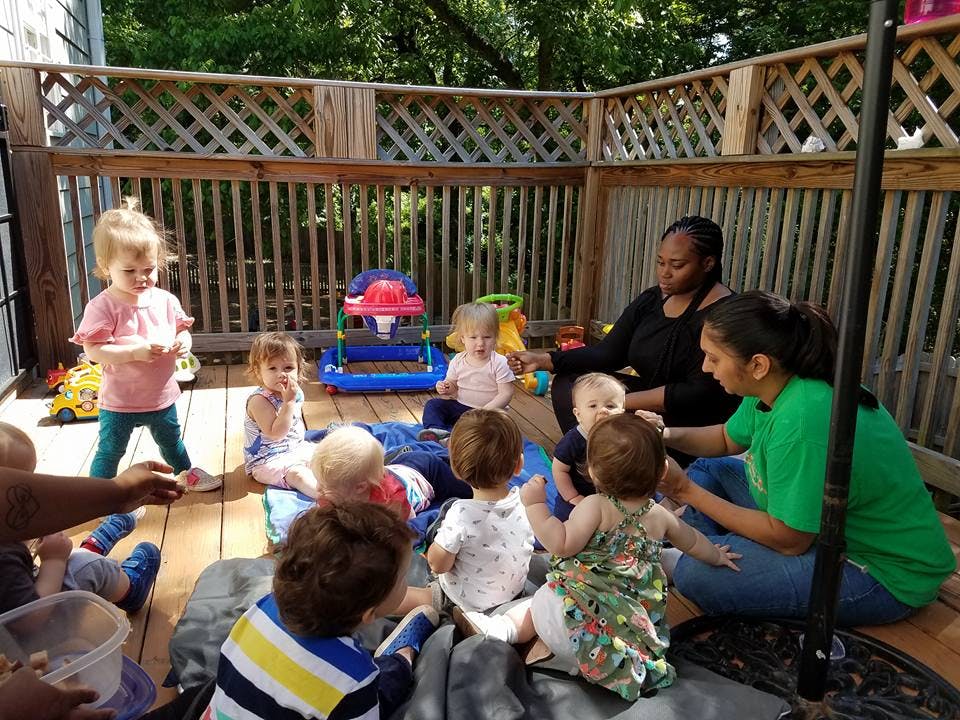 Two people with a group of children on a deck